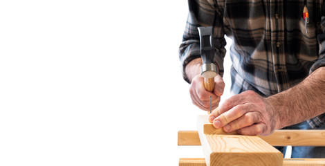 Close-up. Carpenter with hammer and nails fixes a wooden board. Construction industry, do it yourself. White background.
