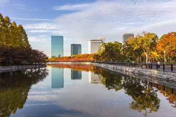 Fototapeta na wymiar Cloudscape and skyline urban cityscape reflection at Osaka Castle Park, Japan.