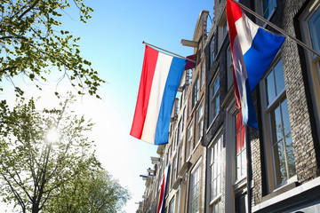 Red,white and blue natioinal flags of Kingdom of Netherlands in center of Amsterdam