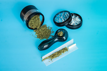 ground marijuana buds on a metal grinder. Ground Cannabis Flowers Before Use on blue Background