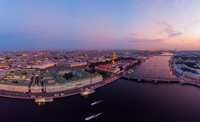 Obraz premium Beautiful aerial evning view in the white summer nights of St Petersburg, Russia, Hermitage at sunset, palace square, St. Isaac's Cathedral, The Alexander column, River Neva. shot from drone. Europe.
