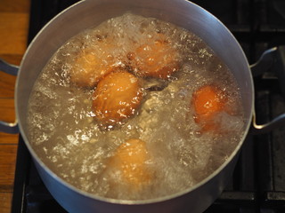 Homemade food. Chicken eggs are cooked in a saucepan over a fire. Preparing a filling for pies.