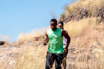 Young Black Couple Running at Forest Trail.