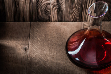 decanter with red wine on wooden background