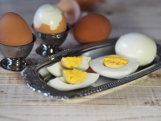 Chicken eggs on a wooden rustic white table. Purified and unpeeled. Shells. Preparing a filling for pies. Homemade food.