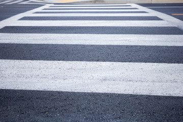 A closeup low angle view of a crosswalk in the shade.