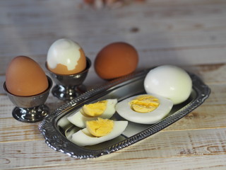 Chicken eggs on a wooden rustic white table. Purified and unpeeled. Shells. Preparing a filling for pies. Homemade food.