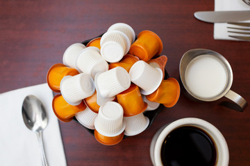 A top down view of a bowl of non-dairy creamer cups in a restaurant setting.