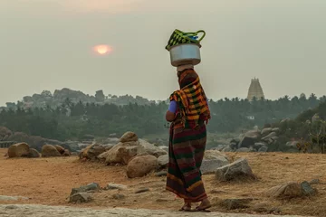 Foto auf Acrylglas Heringsdorf, Deutschland Eine indische Frau trägt eine schwere Last auf ihrem Kopf. Indien. Karnataka