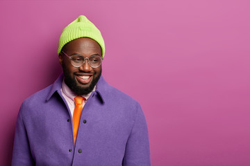 Human facial expressions and emotions concept. Handsome black man with cheerful expression, looks...
