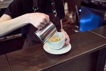 coffee in the hands of baristas on a dark background