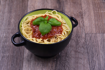 Spaghetti pasta with tomato sauce on wooden table stock images. Bowl of spaghetti. Spaghetti with basil on a wooden background with copy space for text. Spaghetti top view with copy space