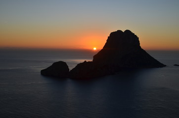 sol despidiendose en el horizonte del mar mediterraneo entre los islotes de ibiza