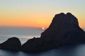 Fototapeta premium sol despidiendose en el horizonte del mar mediterraneo entre los islotes de ibiza