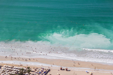 background top view of the beach in the Dubai Marina area, with clear green water and white sand, in Dubai, UAE