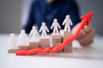 Businessperson's Hand Holding Red Arrow