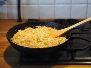 Home cooking. Fried cabbage in a black pan over a fire. Preparing the filling for the pie with cabbage.
