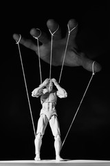 Concept of control. Marionette in human hand. Black and white image