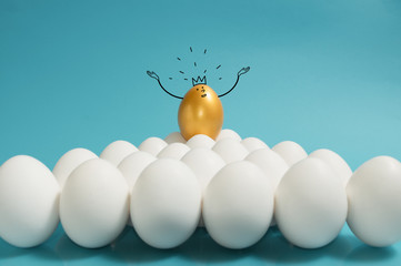 Business recruitment, talent management. One golden egg with crown in top of white eggs group on blue background. - obrazy, fototapety, plakaty