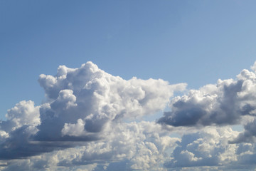 Rough white cumulus clouds on blue sky before rain. With clear blue sky from above