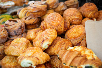 A view of several varieties of French pastries on display at a local bakery, featuring croissants.