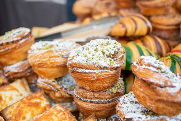 A view of several varieties of French pastries on display at a local bakery, featuring cronuts.