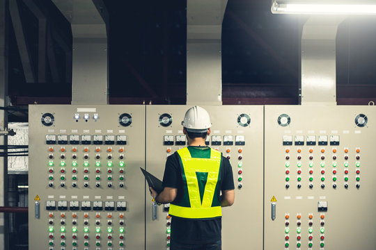 Electrical Engineer team working front control panel, Technician daily check control panel in service room in factory.