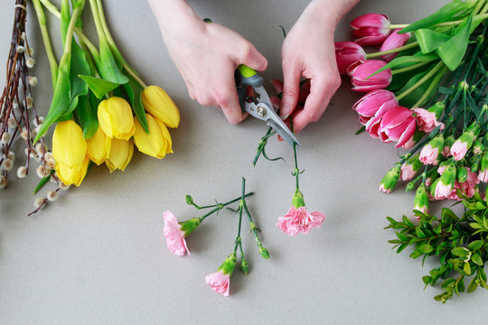 Woman shows how to make beautiful floral arrangement with tulip and carnation flowers