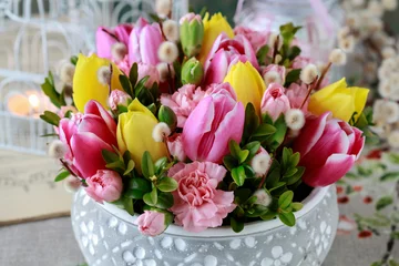 Gordijnen Woman shows how to make beautiful floral arrangement with tulip and carnation flowers © agneskantaruk