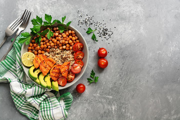 A bowl of healthy salad, fried chickpeas, fried sweet potatoes, avocado, quinoa, tomatoes and...