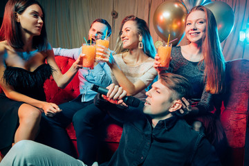 Party, holiday, relax and celebration in karaoke bar, having fun together, singing songs at...