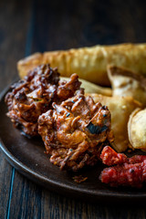 Rava Bhajj or bhajiya also known as suji Pakoda or semolina Pakora with Indian Asian Food Samosas / Samsa, Aloo Tikki and Spring Rolls.