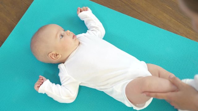 Three month baby boy is receiving massage from mother