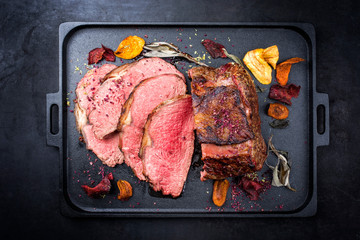 Traditional Commonwealth Sunday roast with sliced cold cuts roast beef with vegetable chips and...
