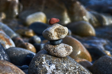 Fototapeta na wymiar Four stones in balance by the sea