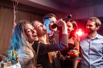 holiday, party,celebration concept. young people have cheerful pastime in karaoke, positive people...