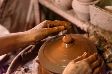 Indian potter making clay pots on pottery wheel in Dharavi Slum at Mumbai