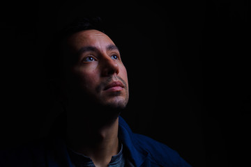 portrait of a young guy in low key on a black background