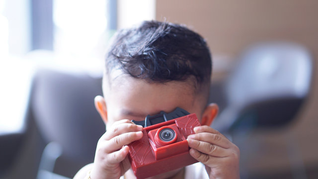 Little Asian boy holding plastic toy camera and take picture.Concept for photography, Photo Education.Kid talent and eye care.