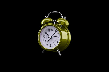 Yellow alarm clock close-up isolated on dark background.