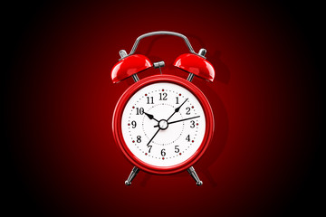 Red alarm clock close-up isolated on dark background with red gradient.