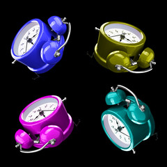 Four color alarm clocks isolated on a dark background.