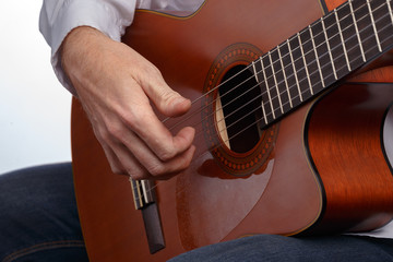 A man plays the guitar. Demonstration of different chords and manners of playing acoustic guitar