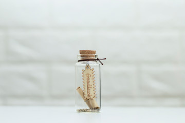 A small lucky sign placed in a small glass bottle