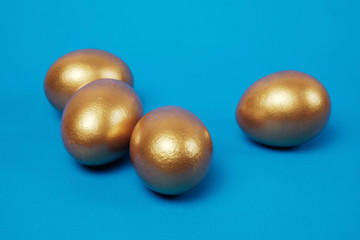 Golden eggs on a blue surface
