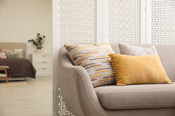Comfortable sofa with different pillows in stylish room interior