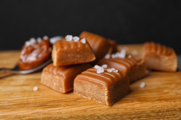 Delicious salted caramel on wooden board, closeup