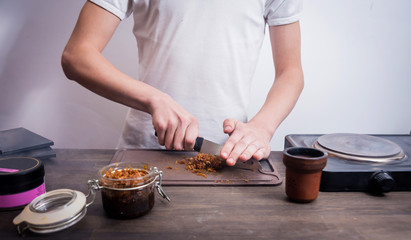 Cooking hookah in the bar. Cutting tobacco into a bowl. Restaurant, hookah bar, smoking cafe.