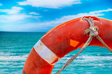 Nature template background with Red lifebuoy and turquoise clear sea in the background. It is...