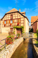 Beautiful traditional colorful house along canal in picturesque Kientzheim village, Alsace wine region, France